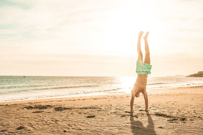 Full length of person on sand at beach against sky