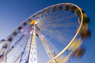 Low angle view of ferris wheel against blue sky