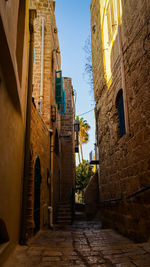 Low angle view of alley amidst buildings against sky