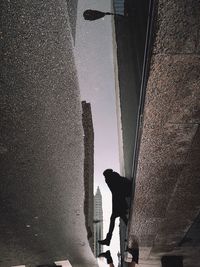 Silhouette man against sky in city