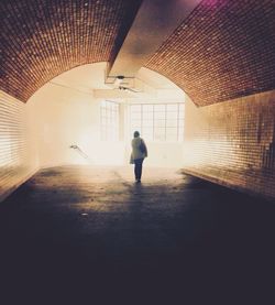 Full length of woman walking in tunnel