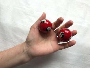 Cropped hand holding yin yang symbol balls