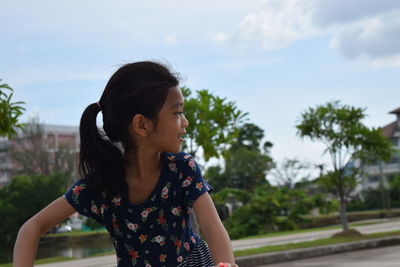 Young woman looking at camera against sky