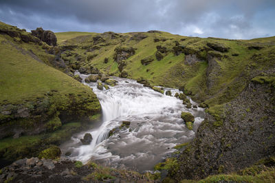 Scenic view of waterfall against sky