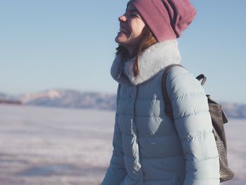 Midsection of woman standing in sea against clear sky