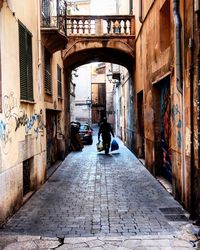 Rear view of people walking on cobblestone street