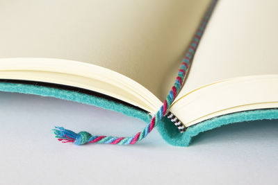 Close-up of colorful bookmark on blank book at table