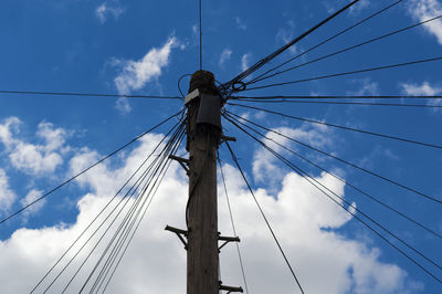 Low angle view of electricity pylon against sky