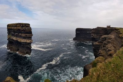 Rock formations on sea shore against sky