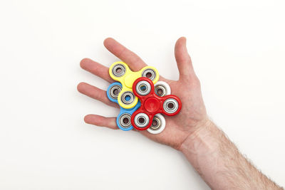 Cropped hand of woman holding pills against white background