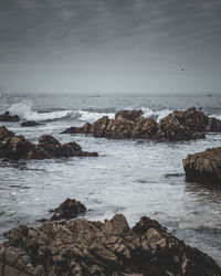 Rocks on beach against sky