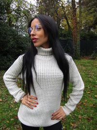 Beautiful young woman standing by tree