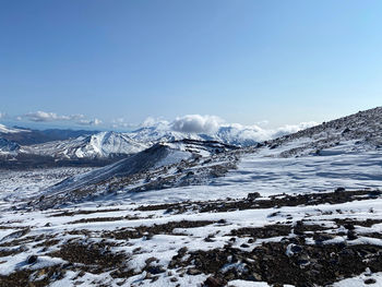Scenic view of snowcapped mountains against blue sky