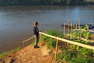 Full length of woman standing by lake