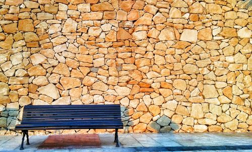 Empty chairs against brick wall