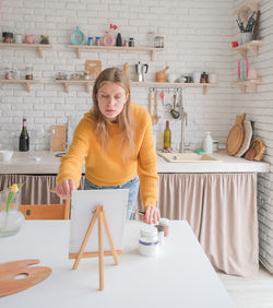 Portrait of young woman sitting at home