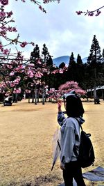Rear view of man and woman against trees