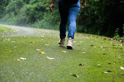 Low section of man walking on road