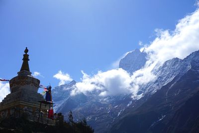 Low angle view of church and mountains against blue sky