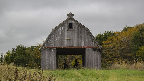 Abandoned house on field against sky