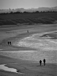 Silhouette people on beach against sky