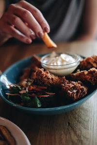 Midsection of person preparing food in bowl on table