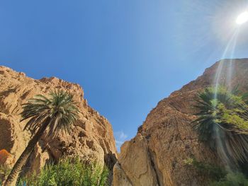 Low angle view of rocks against blue sky