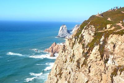 Scenic view of sea and mountains against clear sky