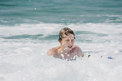 Shirtless young man swimming in sea