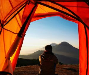 Man standing on mountain against sky during sunset