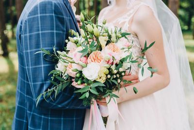 Midsection of woman holding flower bouquet