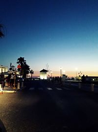 City street against clear sky at sunset