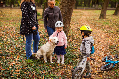 Rear view of people with dog during autumn