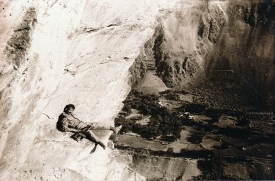 Portrait of army soldier with rifle leaning on rock