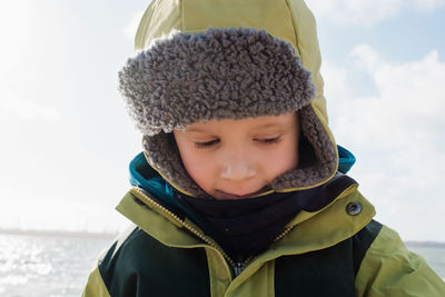 Portrait of a young boy wrapped up warm at the beach in winter