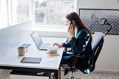 Young female programmer web developer working on computer software in modern office. web designer