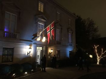 People in illuminated building at night