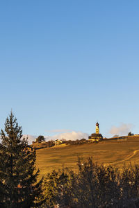 Built structure on field against clear blue sky