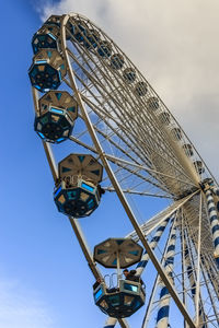 Low angle view of ferris wheel against blue sky