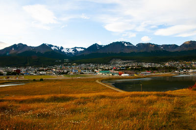 Scenic view of lake by mountains against sky