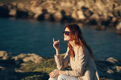 Woman with arms raised at shore