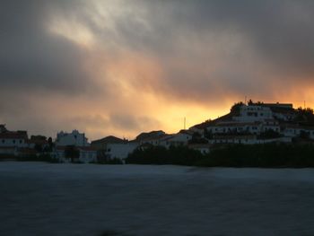 Buildings against cloudy sky at sunset