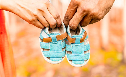 Cropped image of man holding shoes