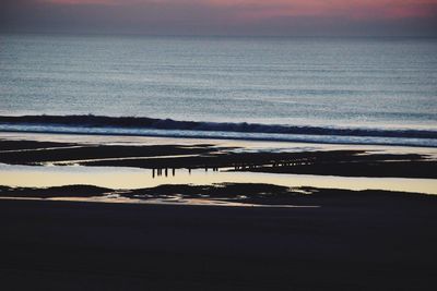 Scenic view of beach against sky during sunset