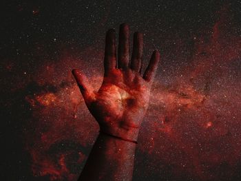 Digital composite image of hand and galaxy