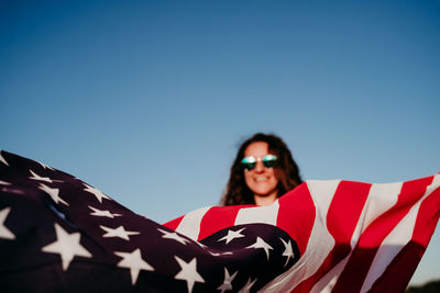 Portrait of young woman against clear blue sky