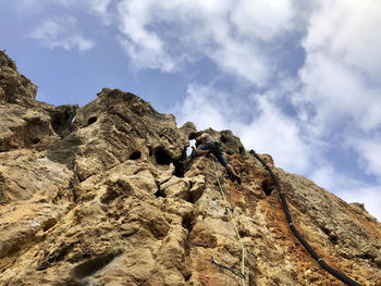 Low angle view of rocks on rock against sky