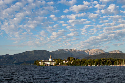 Scenic view of sea by buildings against sky