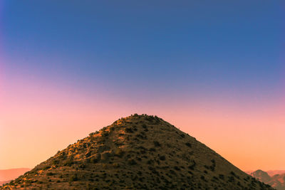 Low angle view of mountain against clear sky during sunset
