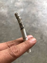 Close-up of hand holding cigarette